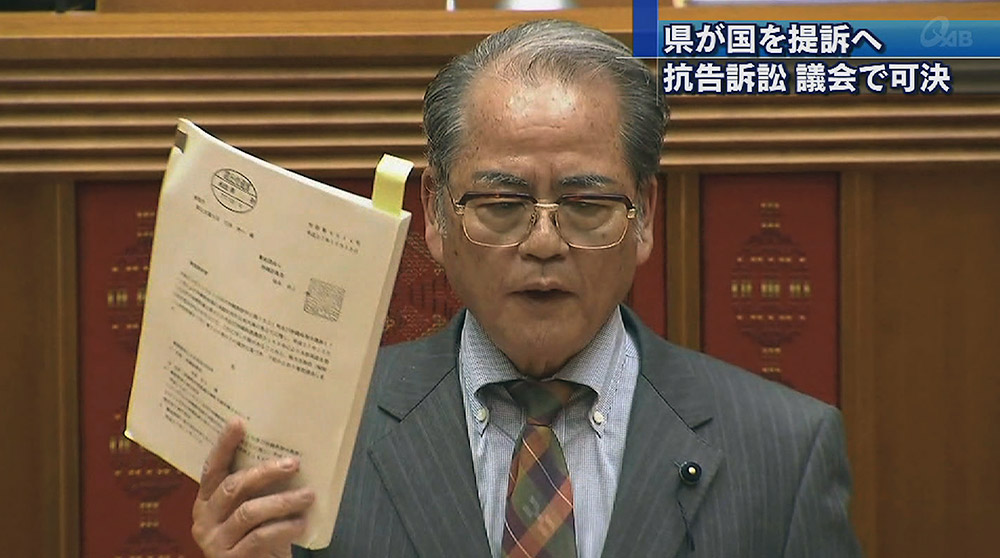 抗告訴訟提起の議案を可決